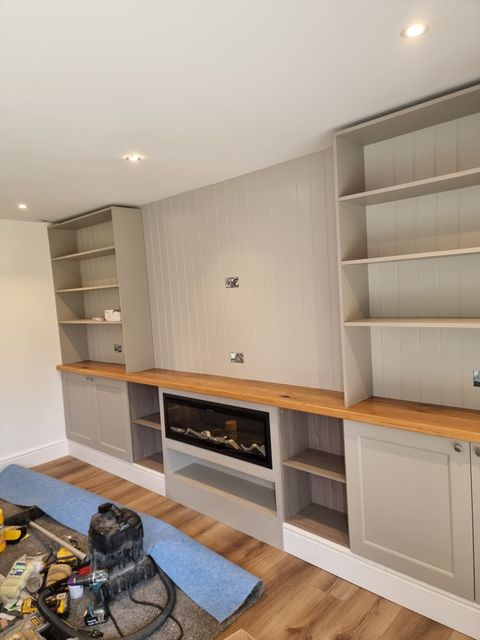 Fitted media wall with oak top, open shelving and inset fireplace