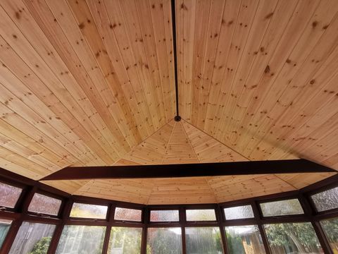 Timber-boarded ceiling fitted inside a conservatory roof conversion