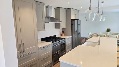 Fitted shaker-style kitchen with range cooker, island and pendant lighting