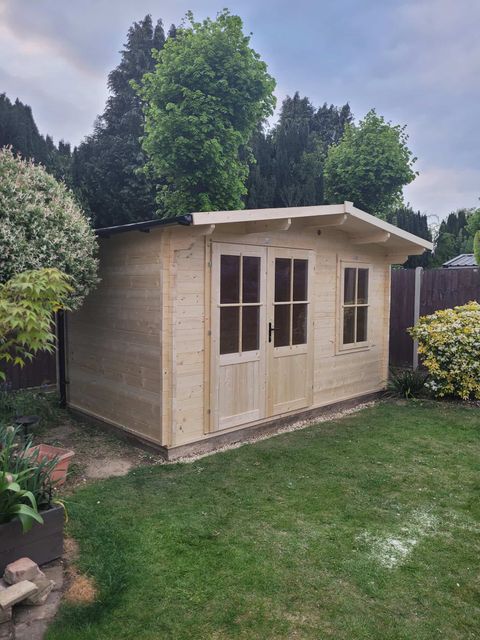 Finished log cabin garden building with double doors and Georgian-bar windows